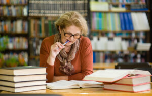 Woman chewing pencil studying for exam