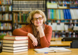 Woman studying in library, taking a break, looking satisfied